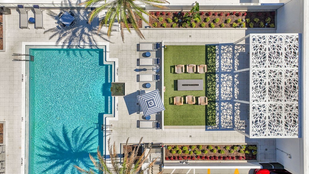 an aerial view of a pool and a backyard with a palm tree