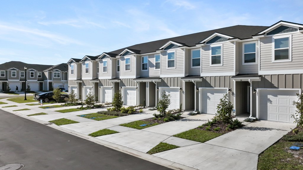 A row of houses with garages and driveways.