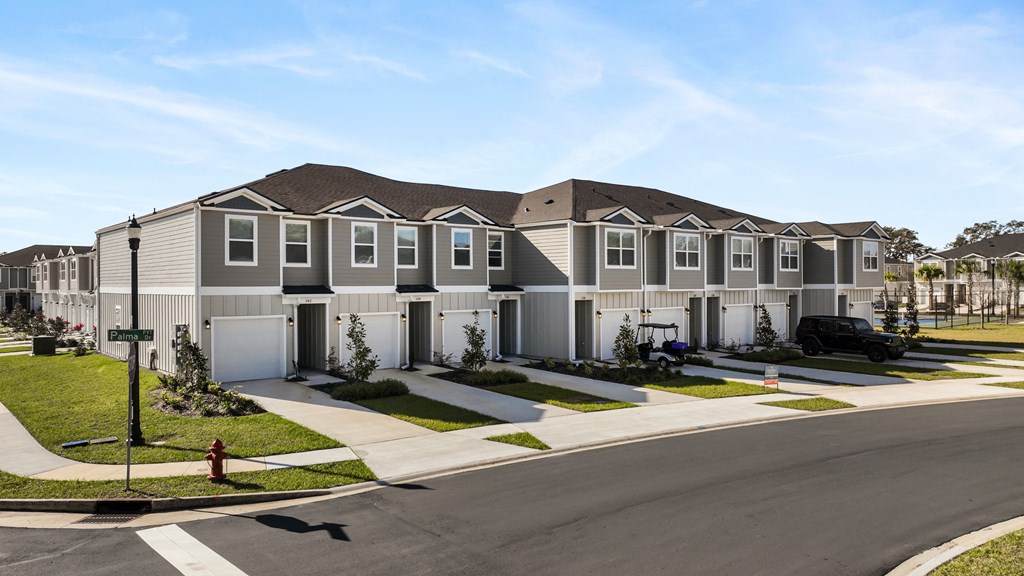 A row of houses with a red fire hydrant in front of them.