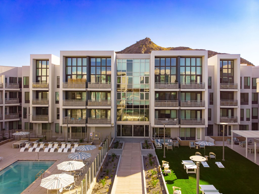 A large building with a pool in front of it.