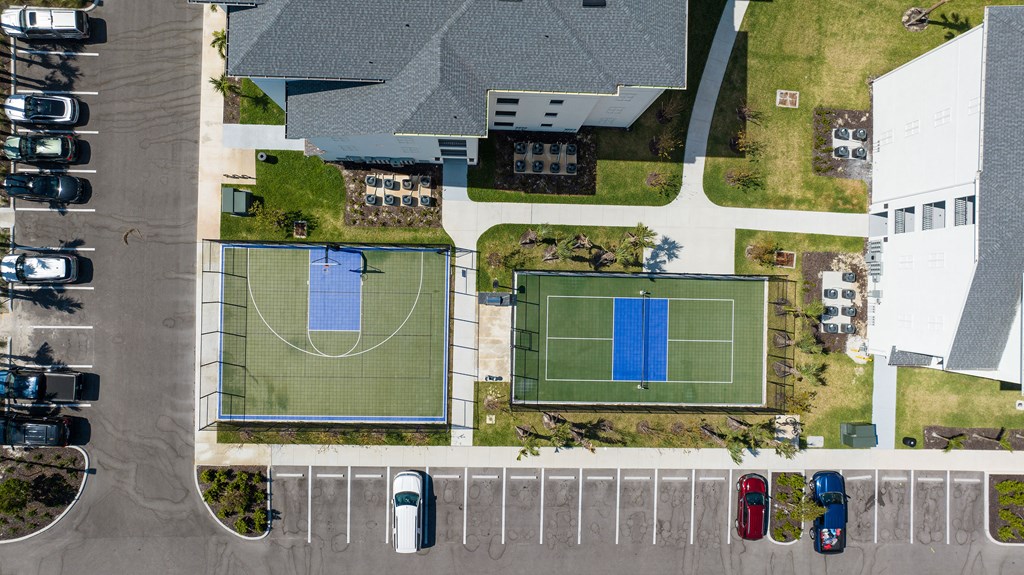 an aerial view of a tennis court and parking lot