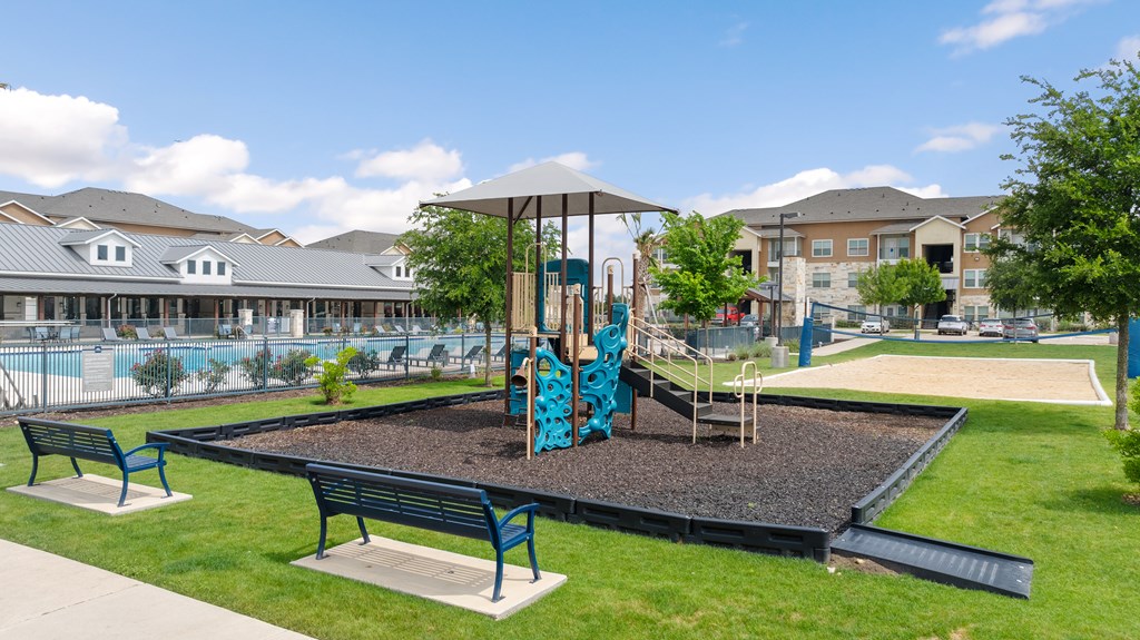 A playground with a slide and two benches.