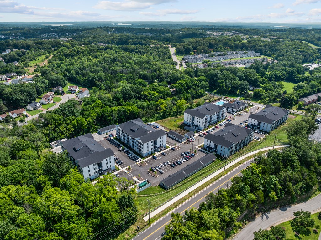 An aerial view of a large white building surrounded by trees.