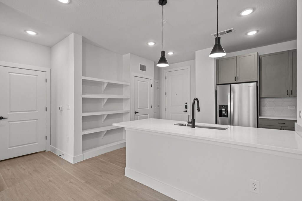 A kitchen with white cabinets and a white counter top.