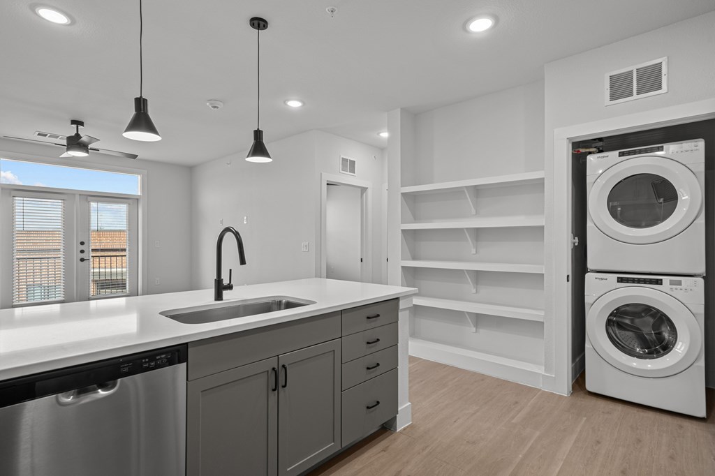 A modern kitchen with a stainless steel dishwasher and a white countertop.
