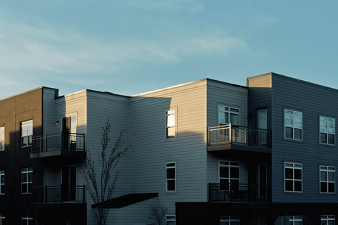 Apartment buildings with balconies and windows are shown in the image.