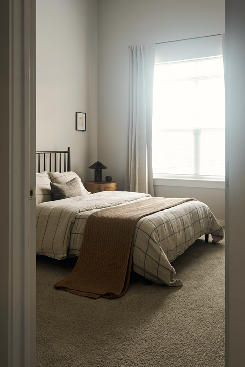 A bedroom with a bed and a window.
