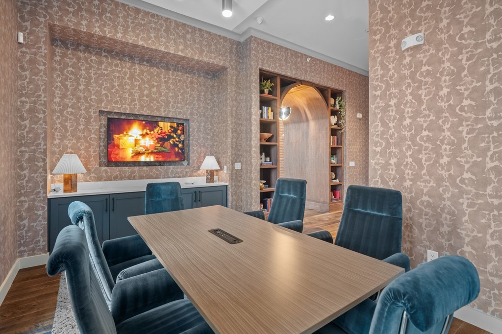 A conference room with a long table and chairs.