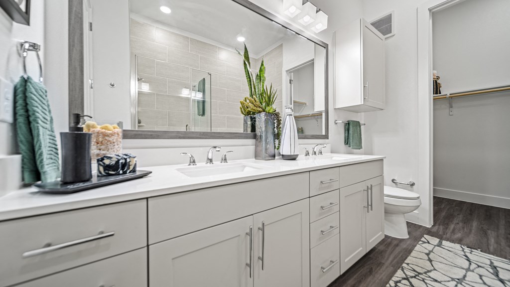 a white bathroom with two sinks and a mirror