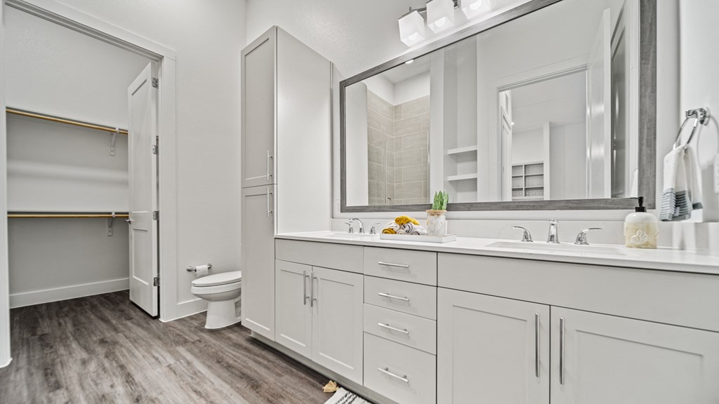 a bathroom with white cabinets and a white toilet and a sink