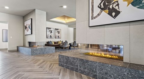 A modern living room with a fireplace and a painting on the wall.