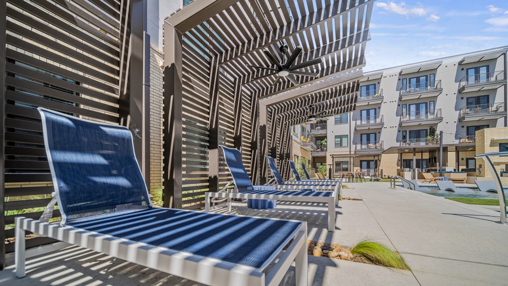 a row of blue and white striped benches on a sidewalk