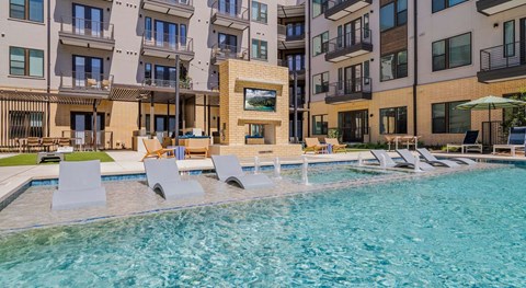A swimming pool in front of apartment buildings.