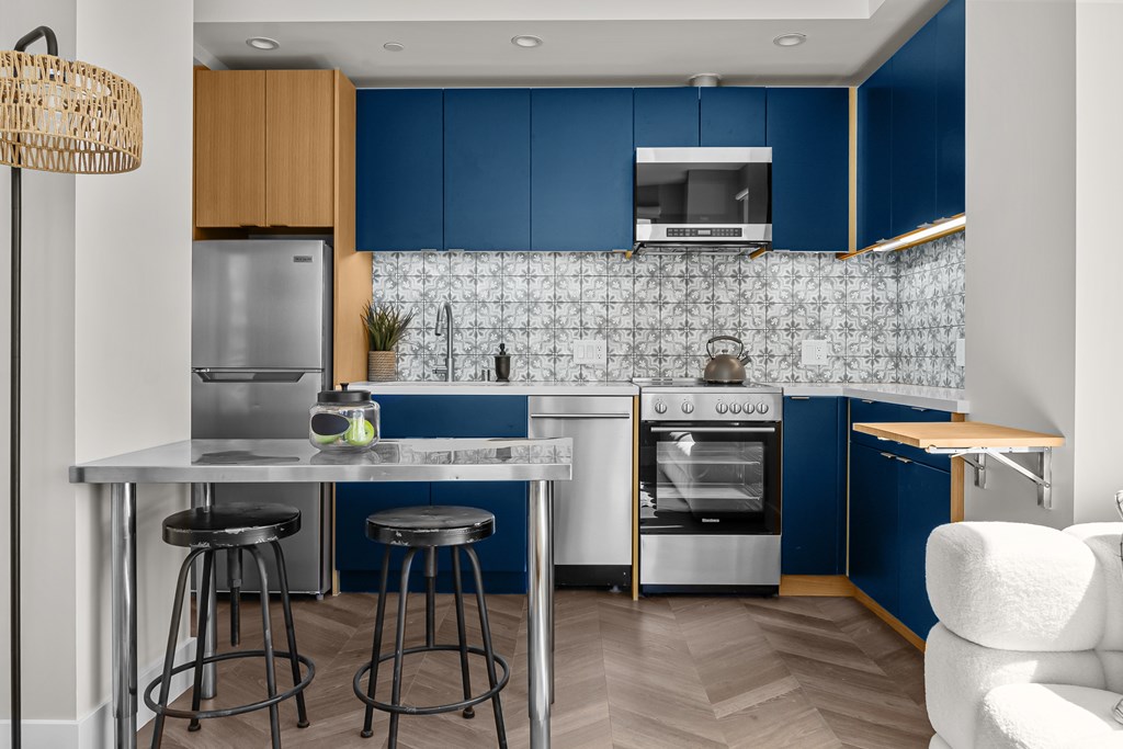 A modern kitchen with blue cabinets and a white island.