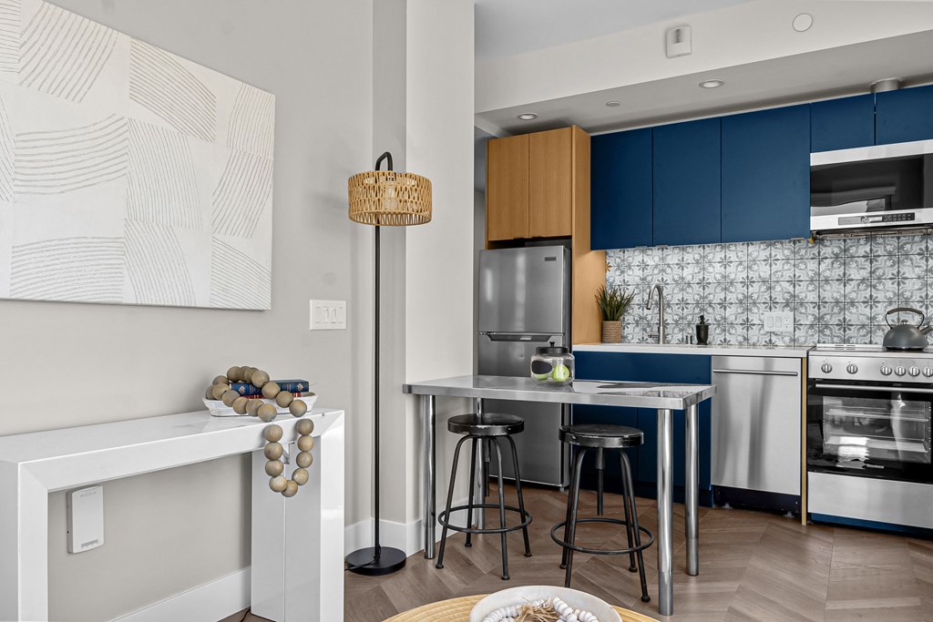 A modern kitchen with a white countertop and blue cabinets.