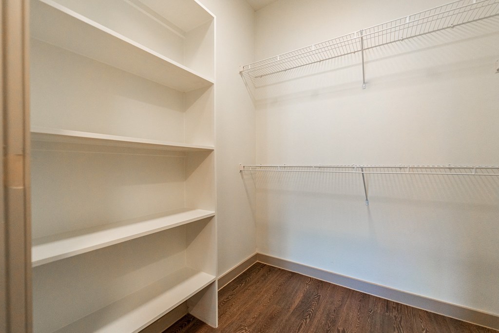 A white shelving unit in a room with wooden floors.
