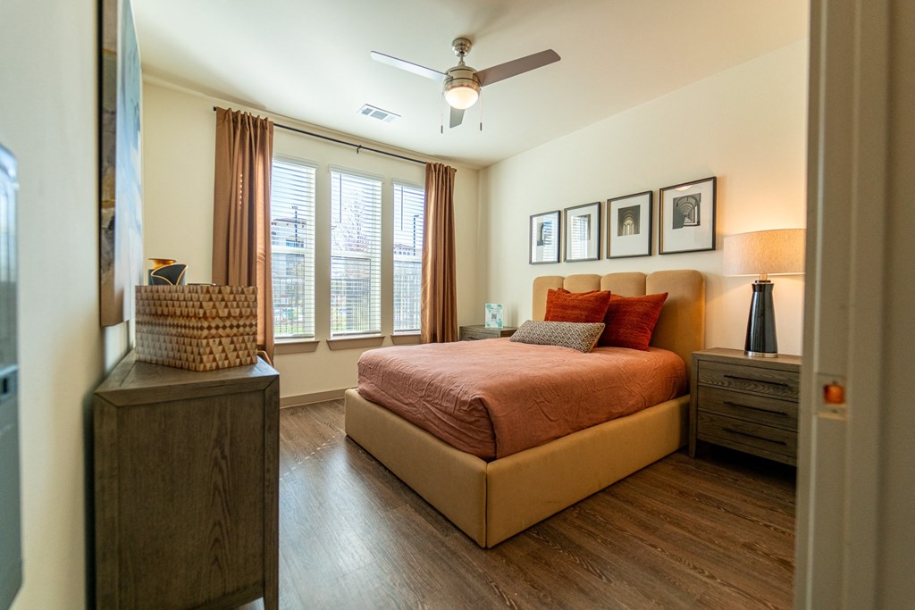 A bedroom with a bed, nightstand, and a ceiling fan.