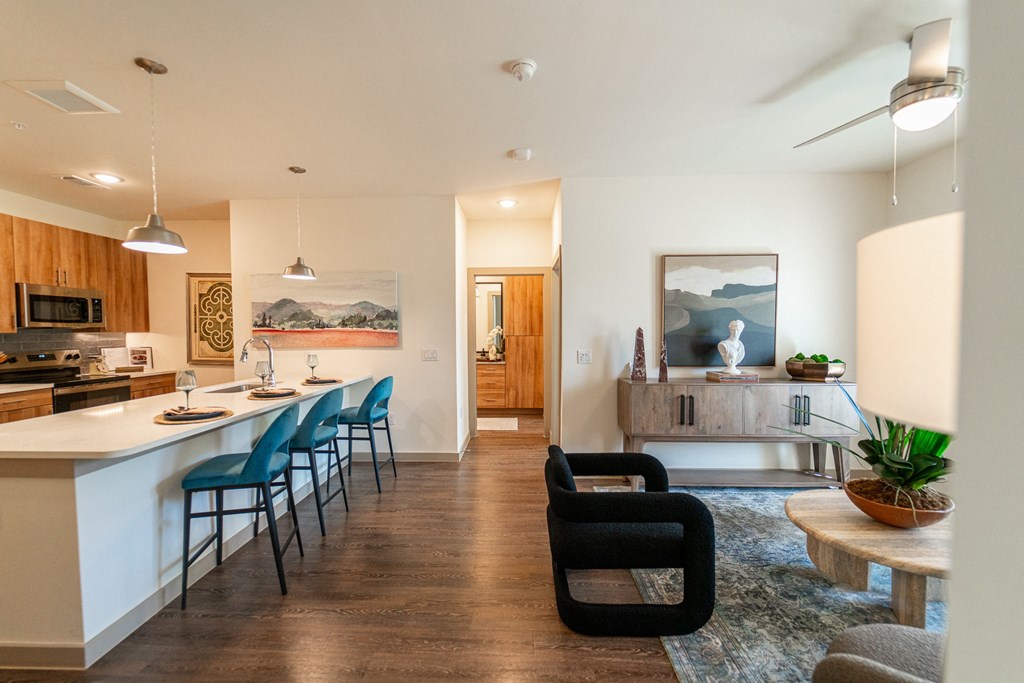 A modern kitchen with a bar and chairs.