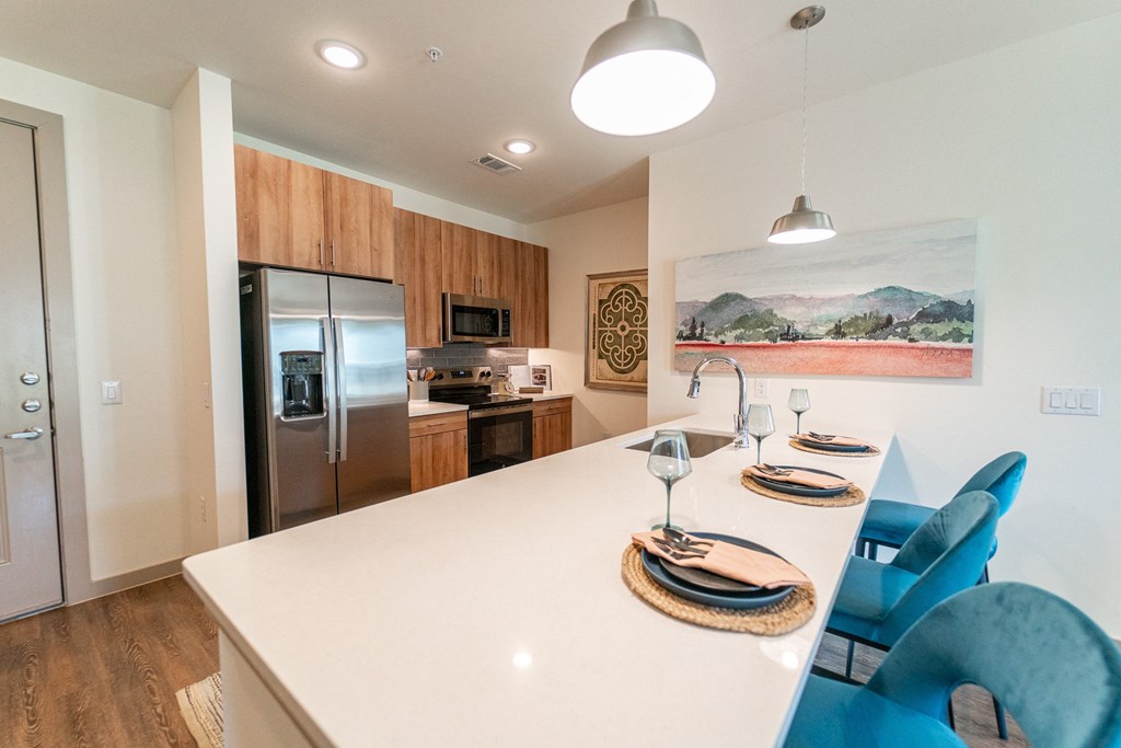 A modern kitchen with a dining table set for two.