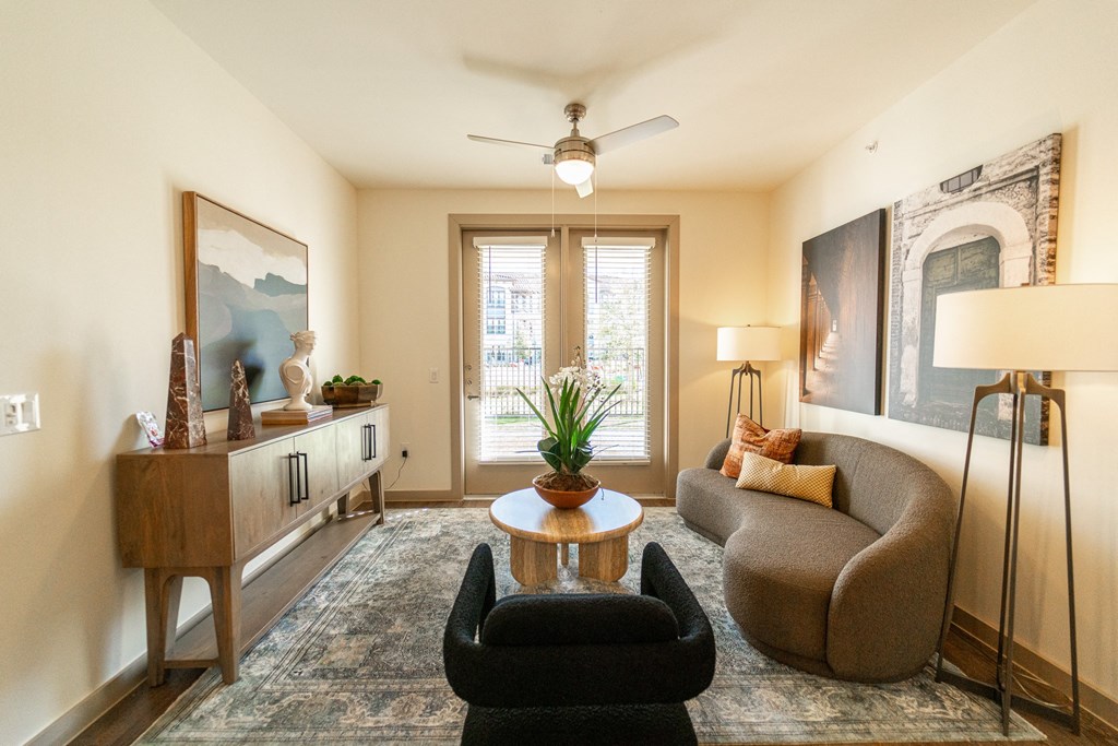 A living room with a black chair and a brown couch.