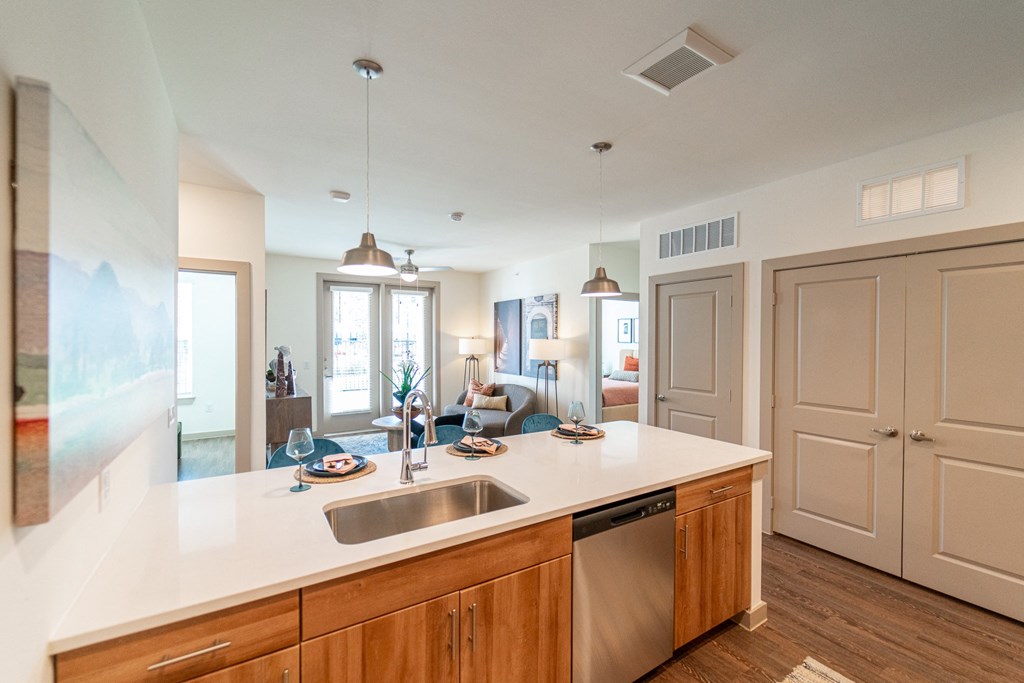 A kitchen with a white counter top and wooden cabinets.