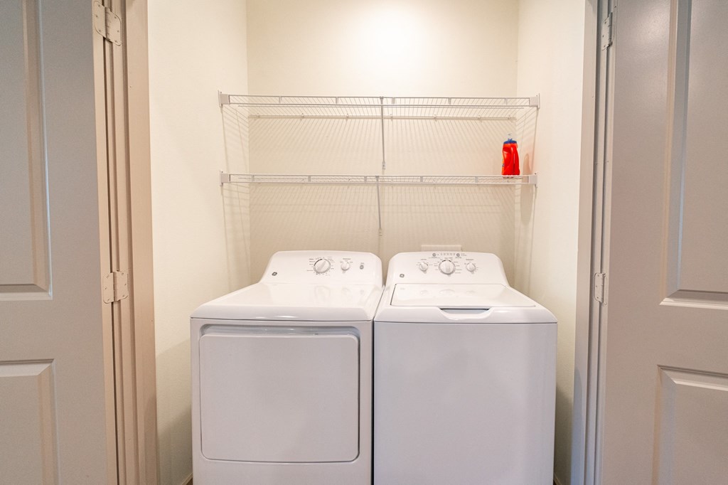 Two white washing machines in a laundry room.