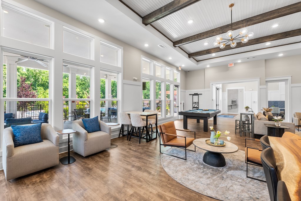 A living room with a pool table and a bar area.