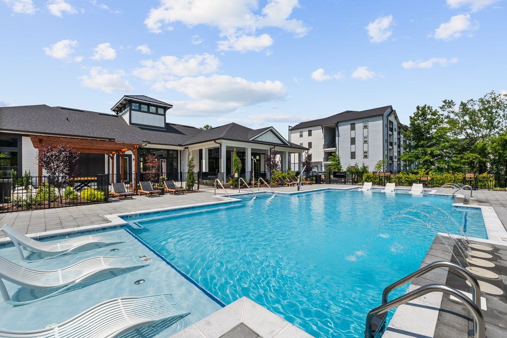 A large swimming pool with a slide and a building in the background.