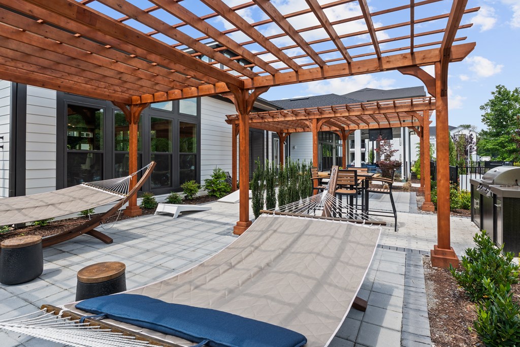 A wooden pergola over a patio with a skateboard ramp.