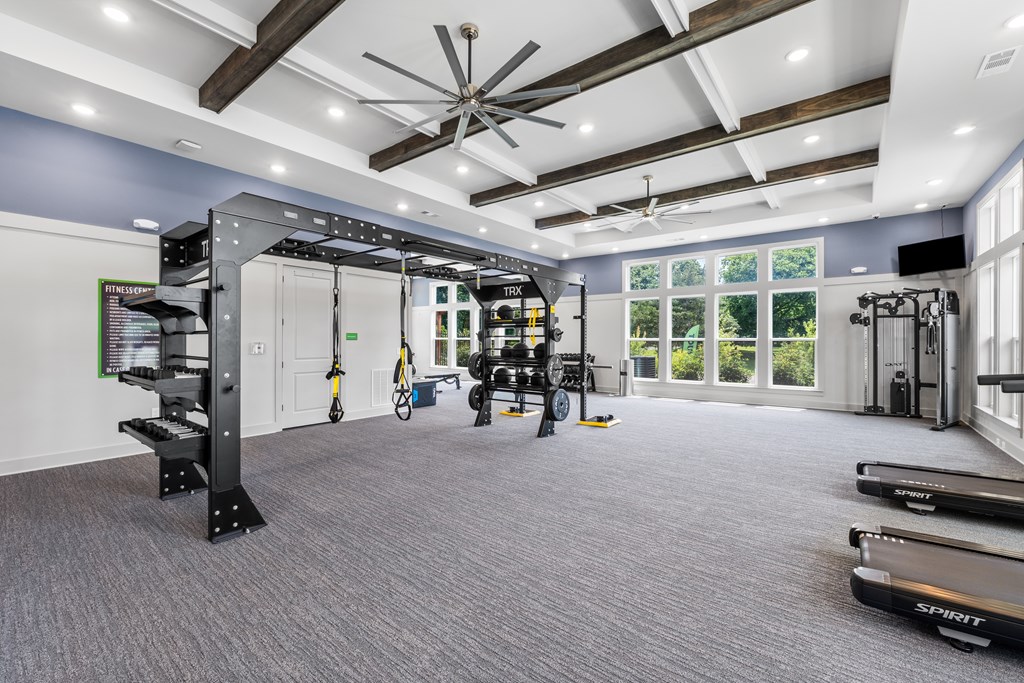 A spacious gym with a variety of equipment and a large window.