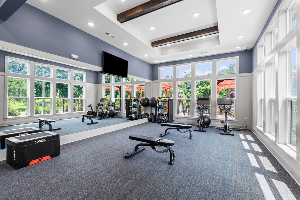 A gym with a variety of equipment including weights and exercise machines.