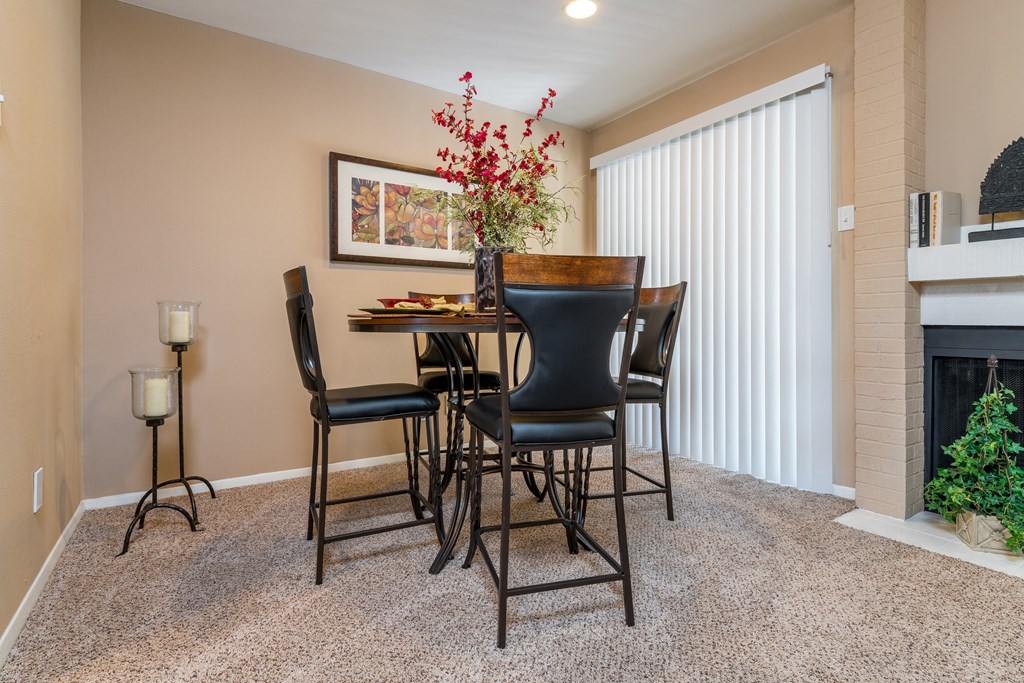 a dining area with a table and chairs next to a fireplace