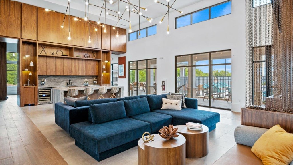 a living room with a blue couch and a kitchen with glass doors
