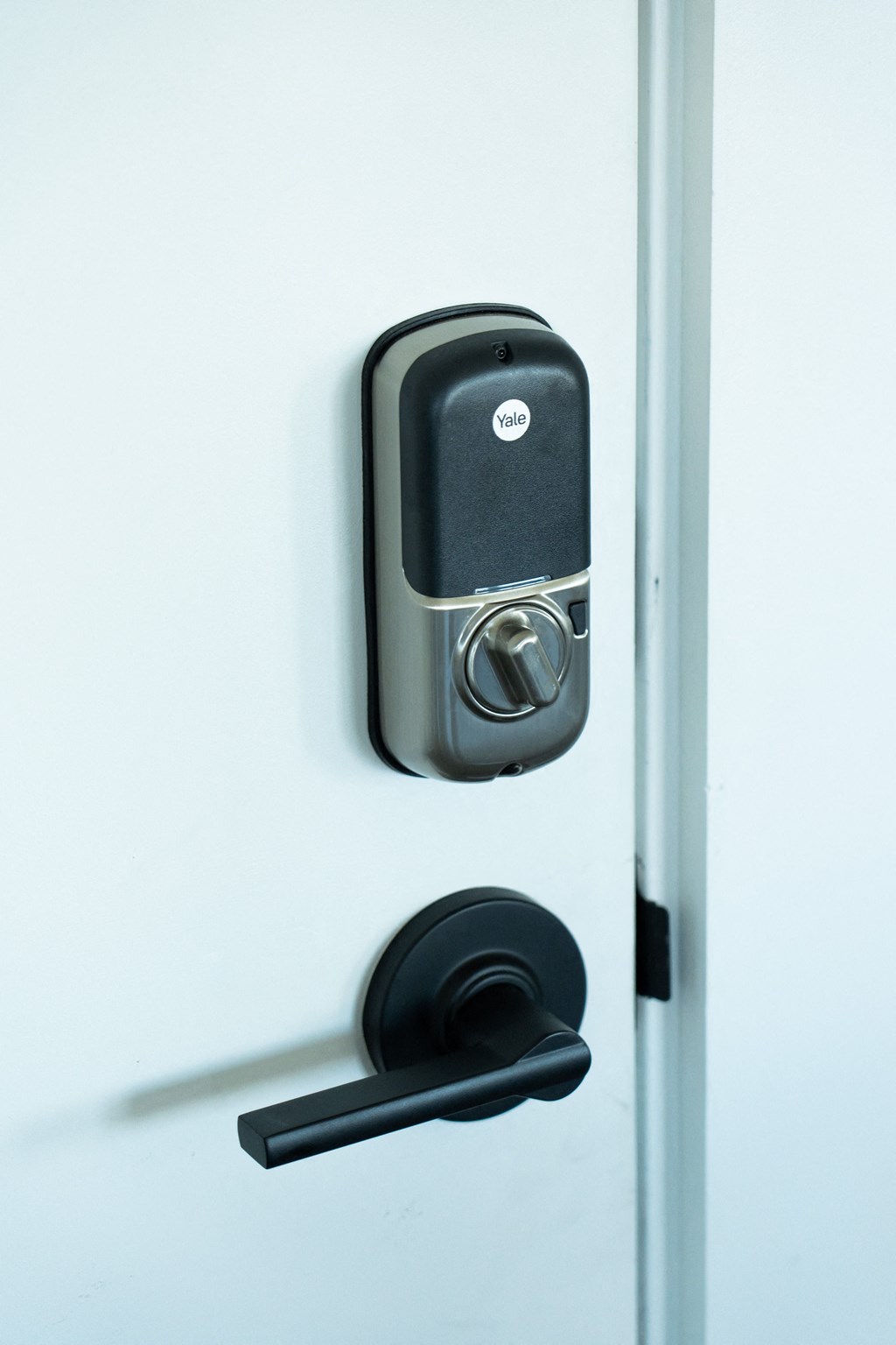 an open door with a black handle and a black door handle on a white door