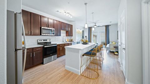 a kitchen with a white counter top and wooden floors