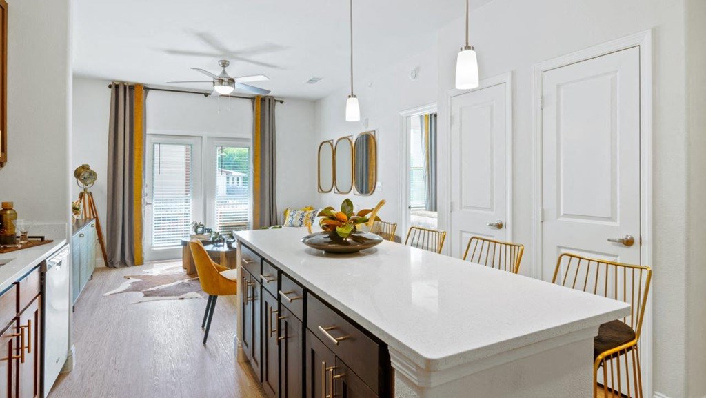 a white kitchen with a large island and a dining room
