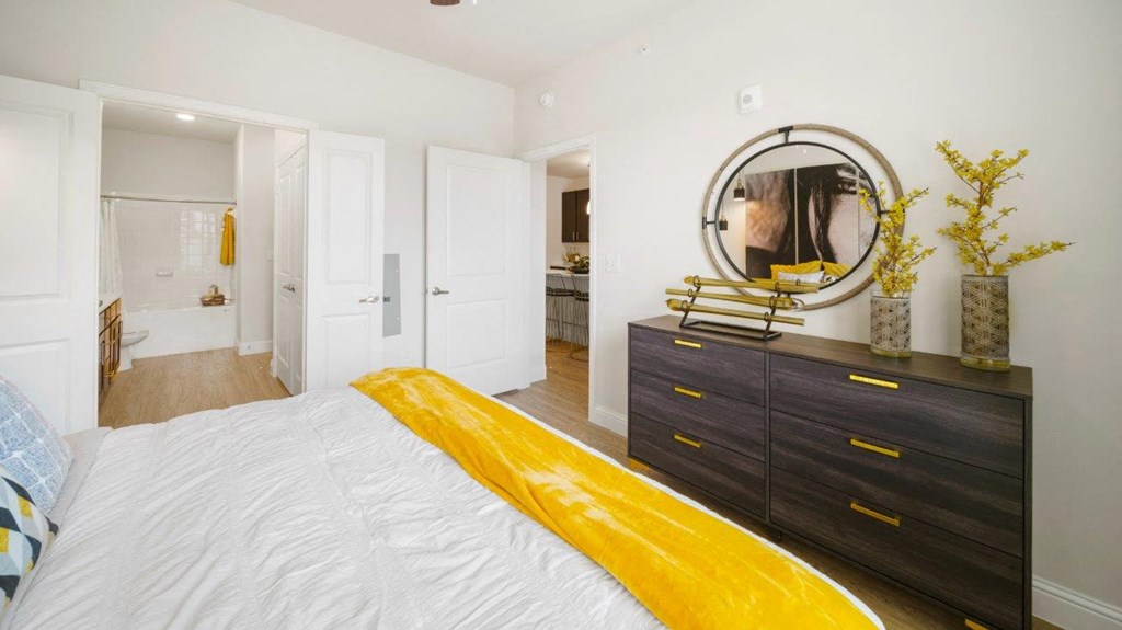 a bedroom with a white bed and a mirror