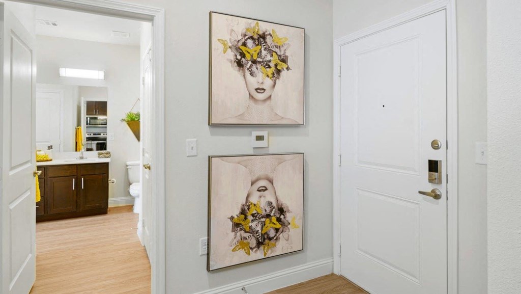 a hallway with two paintings on the wall and a door