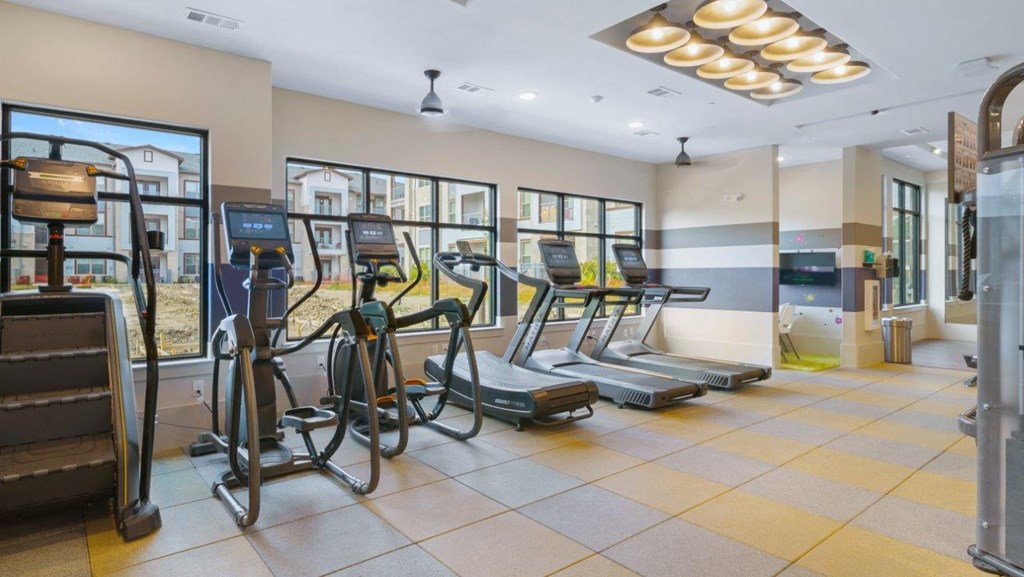 a gym with cardio equipment in the lobby of a building