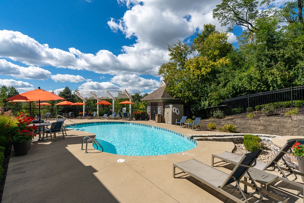 A pool area with a hot tub and lounge chairs.