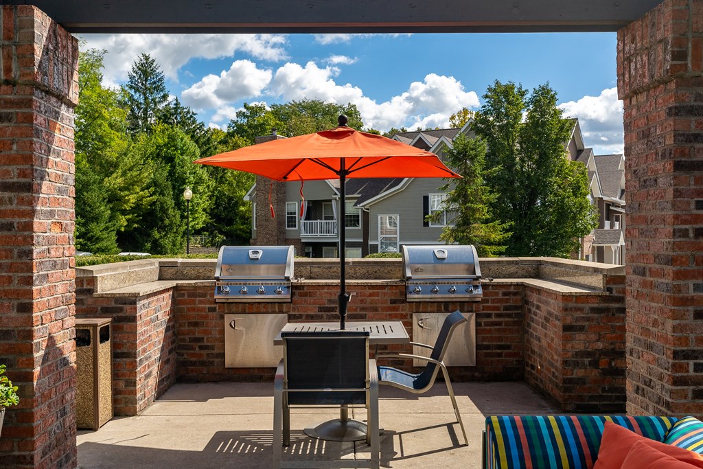 A patio with a table, chairs and an umbrella.
