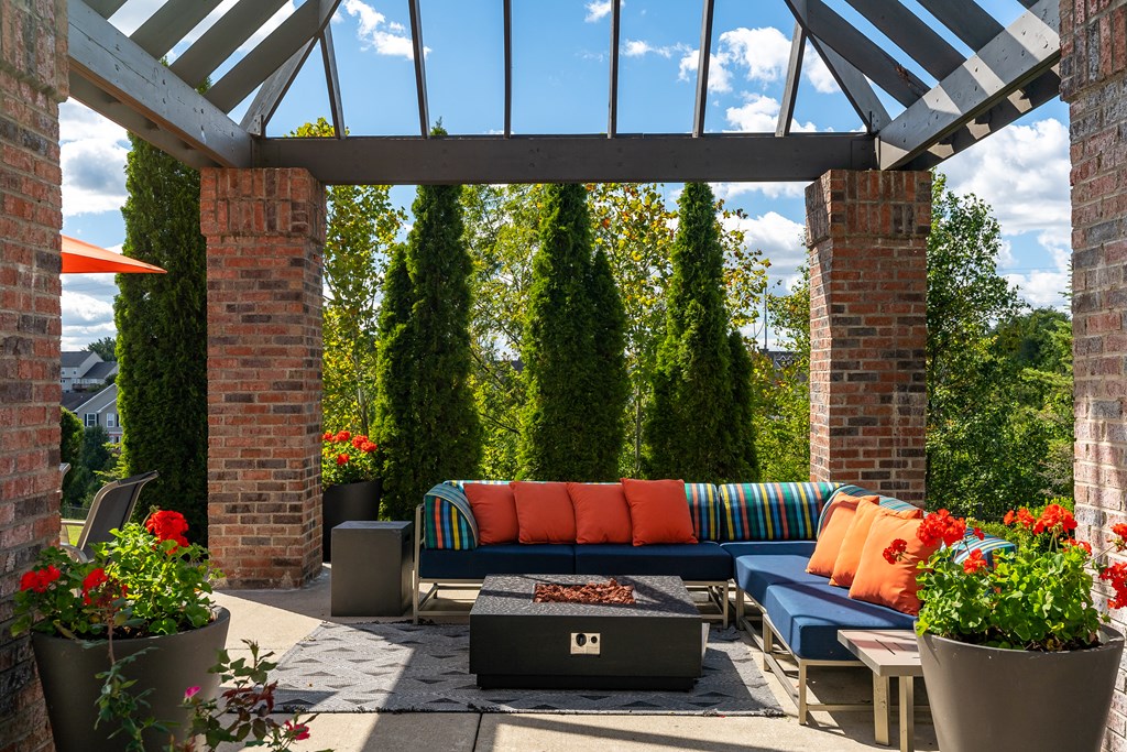 A patio with a couch and a fire pit.