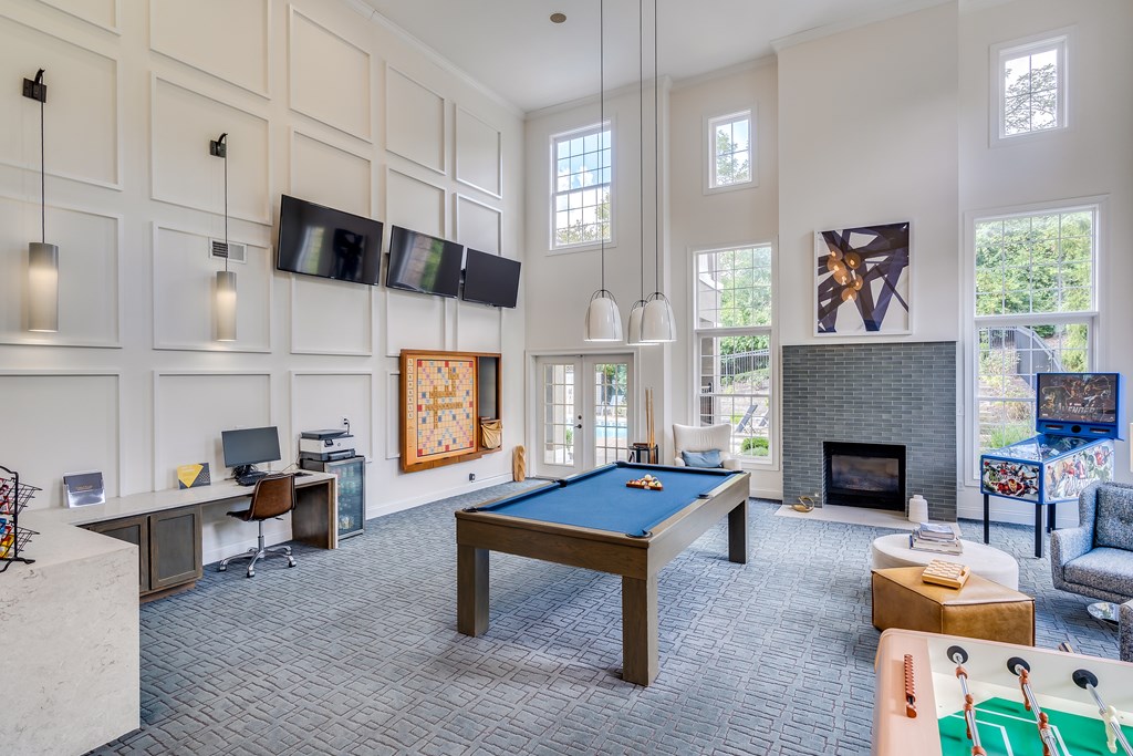 A billiard table is in the middle of a room with a television and a fireplace.