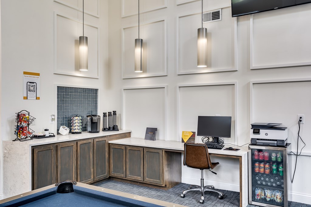 A modern office with a pool table and a desk with a computer.