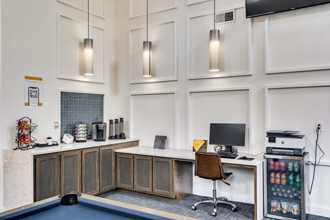 A modern office with a pool table and a desk with a computer.