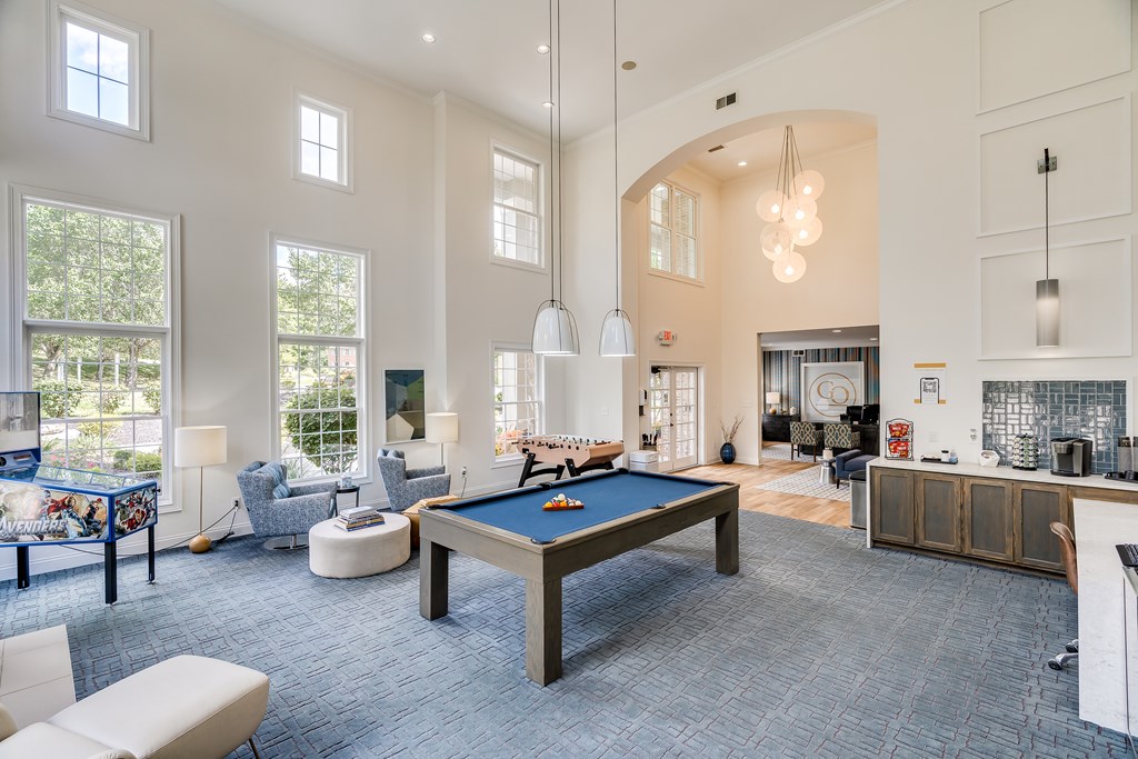 A billiard table is in the middle of a room with a pool table and a couch.