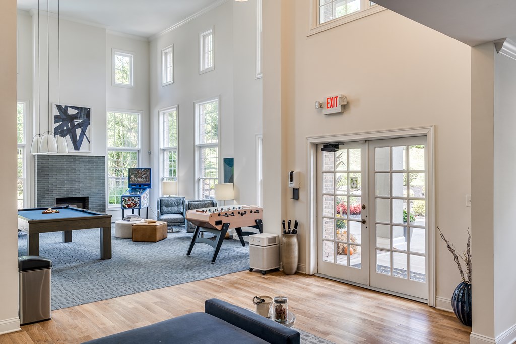 A living room with a pool table and a foosball table.