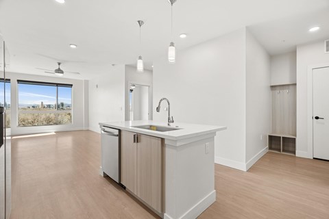 A kitchen with a sink and a window overlooking the city.