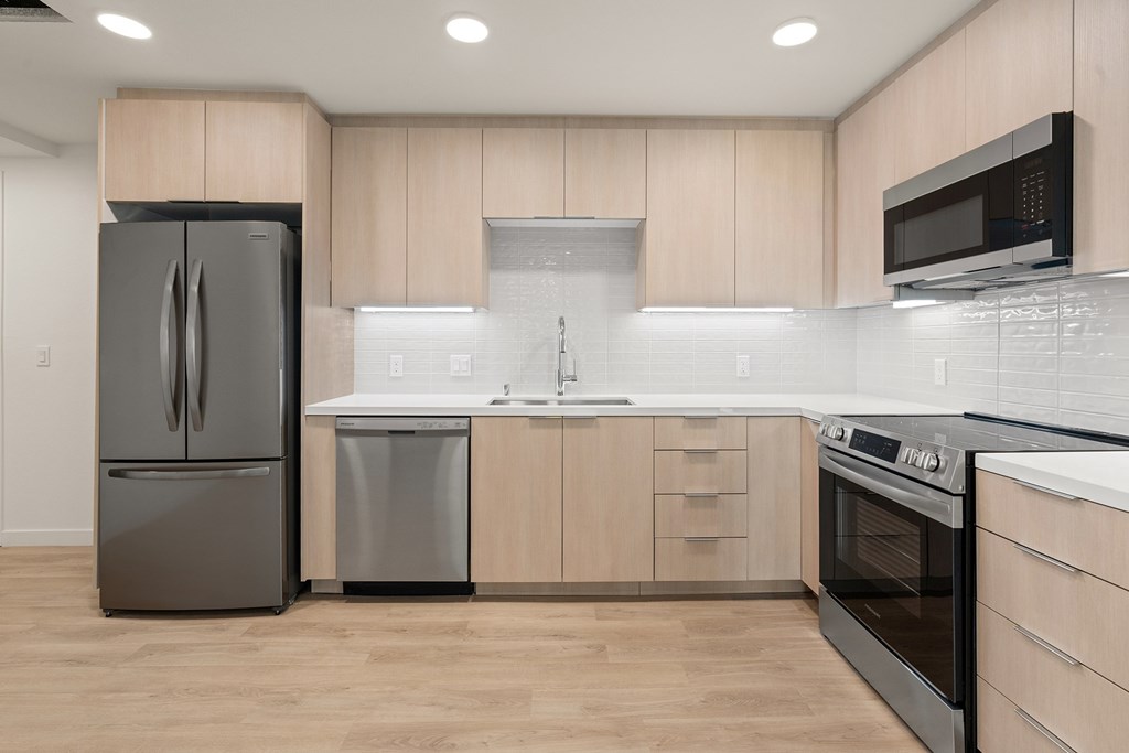 A modern kitchen with wooden cabinets and stainless steel appliances.