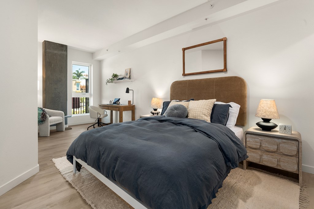 A bedroom with a large bed and a mirror on the wall.